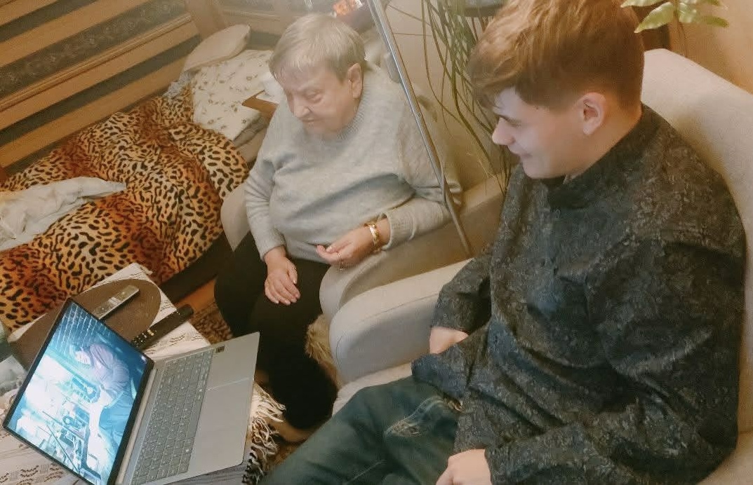 An older adult learning to use a tablet with support